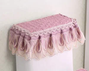Pink quilted toilet tank cover featuring delicate lace embroidery, elegant fabric dust-protector.