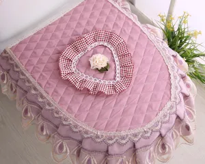 Pink quilted fabric toilet seat cover set with lace ruffles and cute heart decor for bathroom.