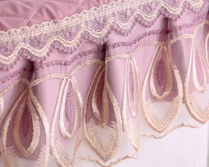 Close-up detail of purple quilted fabric with intricate lace embroidery for home decor.