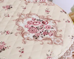 Nahaufnahme des gesteppten, beigen Toilettensitzbezugs mit rosafarbenem Blumenmuster und Spitze.