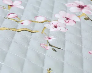 Fabric toilet seat cover detail showing quilted pink floral pattern and soft padded texture.
