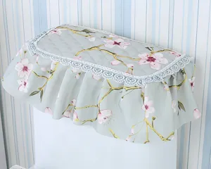 Close-up detail of quilted pastoral fabric water tank cover with cherry blossom print and lace.