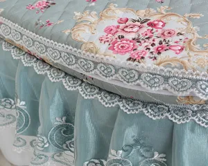Exquisites gestepptes Toilettenstuhldeckdetail mit Vintage Blumenmuster und edlem Spitzenvolant.