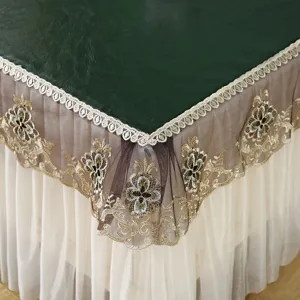 Détail de nappe brodée de dentelle élégante montrant un travail fin et des couches de tissu.