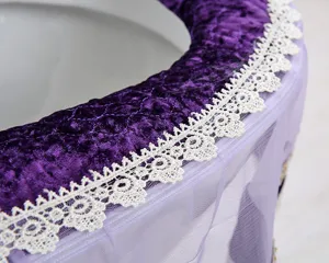 Close-up detail shot of luxury purple velvet toilet seat cover decorated with white lace.