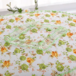 Close-up detail van de gewatteerde toiletbrilhoes met elegante groene kant en bloemenprint.