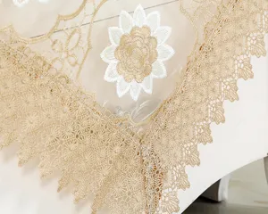 Dettaglio del ricamo a girasole sulla tovaglia in pizzo organza color champagne