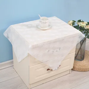 White lace dust cover detail view, elegant floral embroidery for bedside table or small appliance.