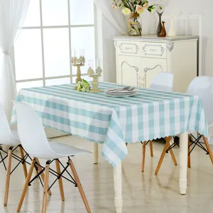 Vue détaillée de la nappe à carreaux bleus et blancs disposée soigneusement sur la table.