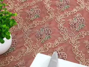 Vista detallada del mantel bordado de encaje rosa, elegante funda de camino de mesa