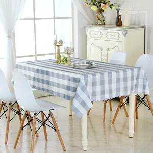 Vue détaillée de la nappe à carreaux bleus et blancs avec bord festonné dans la salle à manger.