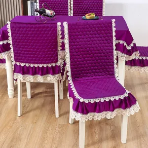 Vue détaillée de la housse de chaise en velours violet et de la nappe assortie en dentelle.