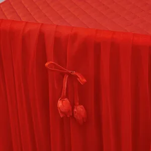 Vista dettagliata della copertura per comodino rossa con parte superiore trapuntata.