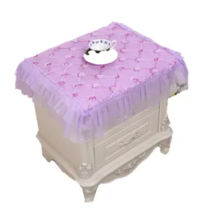 Elegante funda de encaje púrpura para mesita de noche con bordados y bordes volantes.