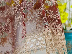Vista detallada de elegante tela de encaje bordado floral, con exquisita textura y acabado.