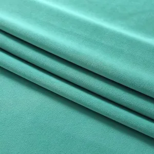 Gros plan sur le detail de la texture du tissu velours vert menthe doux et tres elegant.