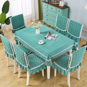 Vue détaillée de la nappe de table en velours teal et des housses de chaise avec dentelle.