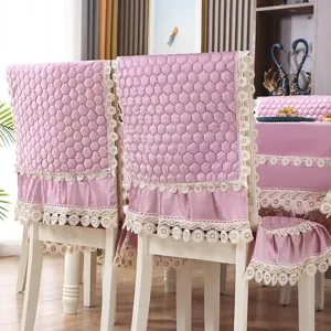 Détails de la housse de chaise de salle à manger en velours rose et nappe avec dentelle.