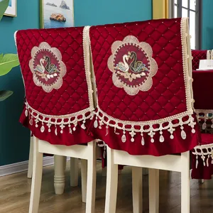 Red velvet dining chair cover set with elegant swan embroidery, diamond quilting and lace fringe.