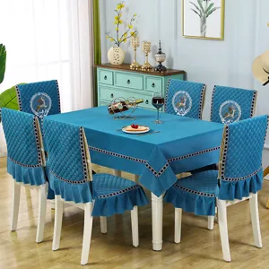 Detailed view of blue velvet dining chair covers and tablecloth set with deer embroidery.