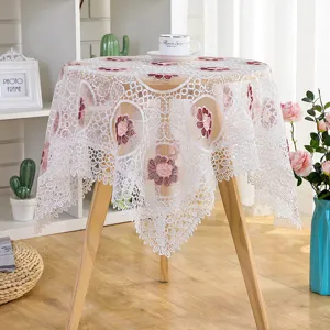 Detailed view of white floral lace tablecloth with exquisite hollow embroidery design.