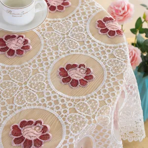 Detailed view of white lace embroidered tablecloth, elegant floral design for home table decor.