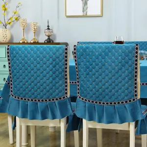 Teal quilted dining chair cover set with elegant ruffle skirt and geometric trim detail.
