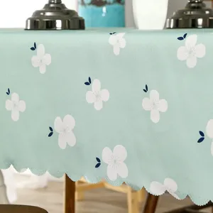Détail de nappe verte imperméable avec motif floral blanc élégant pour décoration table.