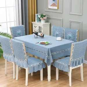 Ensemble de nappe et housses de chaise capitonnées bleu clair avec broderie florale et volants.