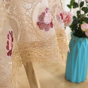Detailed shot of elegant lace embroidered hollow tablecloth, perfect for home table decoration.