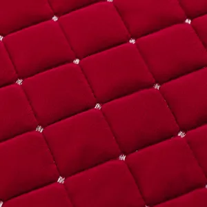 Red Italian velvet chair cushion fabric detail, soft plush quilted texture close up view.