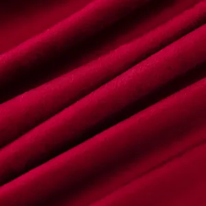 Detailed close-up of soft red velvet fabric showcasing rich texture and elegant drapes.