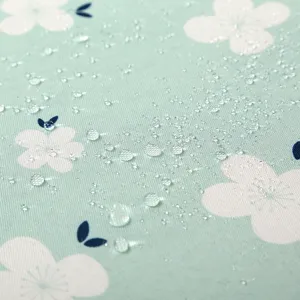 Gros plan détail du tissu de nappe imperméable à motif floral et perles d'eau vert menthe