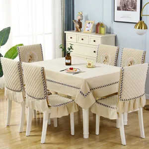 Detailed view of quilted flannel dining chair cover and matching beige tablecloth for home decor.