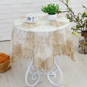 Elegant lace embroidered tablecloth with gold floral pattern and fringe edge for home table decor.