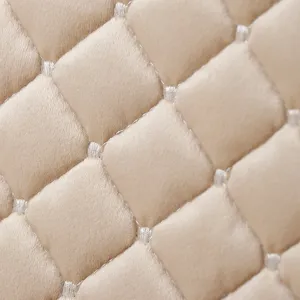 Close-up detail of quilted Italian velvet fabric with diamond pattern, soft beige texture.