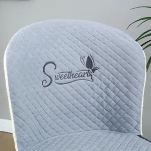Quilted grey dining chair cover with elegant butterfly embroidery and backrest design.