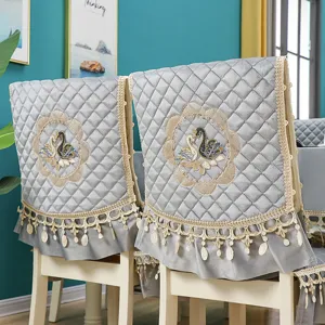 Grey velvet dining chair cover with quilted diamond design, elegant swan embroidery and lace trim.