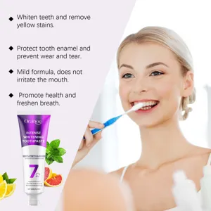 Close-up view of whitening toothpaste tube and model brushing teeth for daily oral care.