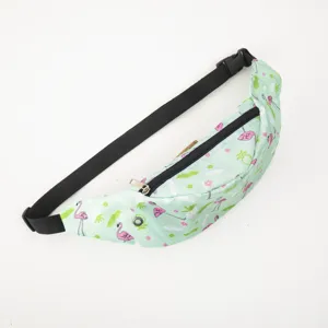 Close-up detail of a light green sports waist bag featuring pink flamingo and pineapple prints.
