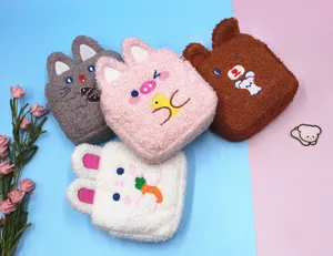 Close-up of four cute plush animal-shaped cosmetic bags with embroidered cartoon faces