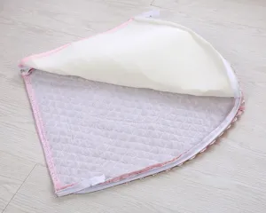 Detail shot of pink quilted plush toilet seat cover with lace trim and zipper closure.