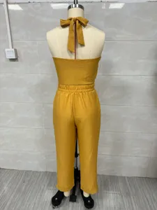 Back detail view of the yellow halter neck linen blend jumpsuit showing the elastic waist and tie.