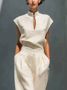 Elegant beige sleeveless top and high-waist trousers detail showing refined tailoring.