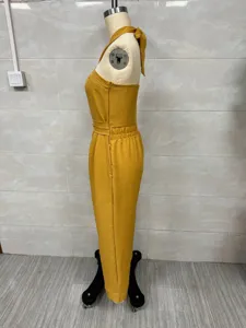 Side detail view of a bright yellow halter neck linen blend casual jumpsuit displayed on a mannequin.