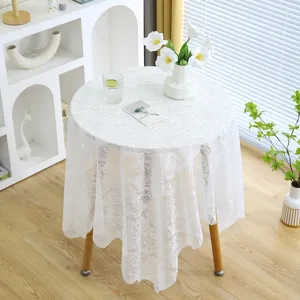Détail de la nappe en dentelle blanche avec broderie florale et accents de perles
