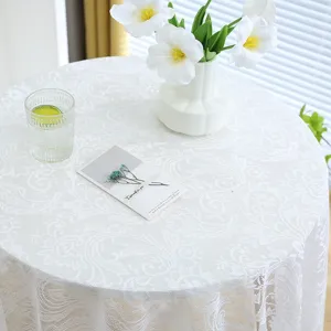 Gros plan d'une élégante nappe en dentelle blanche brodée aux motifs floraux délicats.