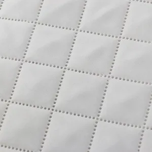 White quilted dust cover fabric detail showing neat grid stitch pattern for home appliances.