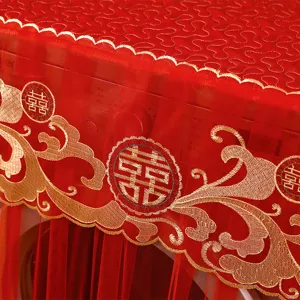 Detail der roten Spitzen-Waschmaschinenabdeckung mit Goldstickerei und Motiven.