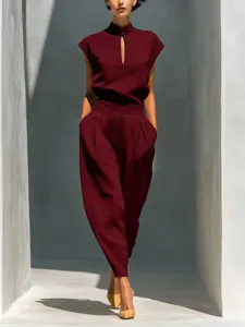 Detail view of elegant women's mandarin collar cutout top and high-waisted barrel pants.